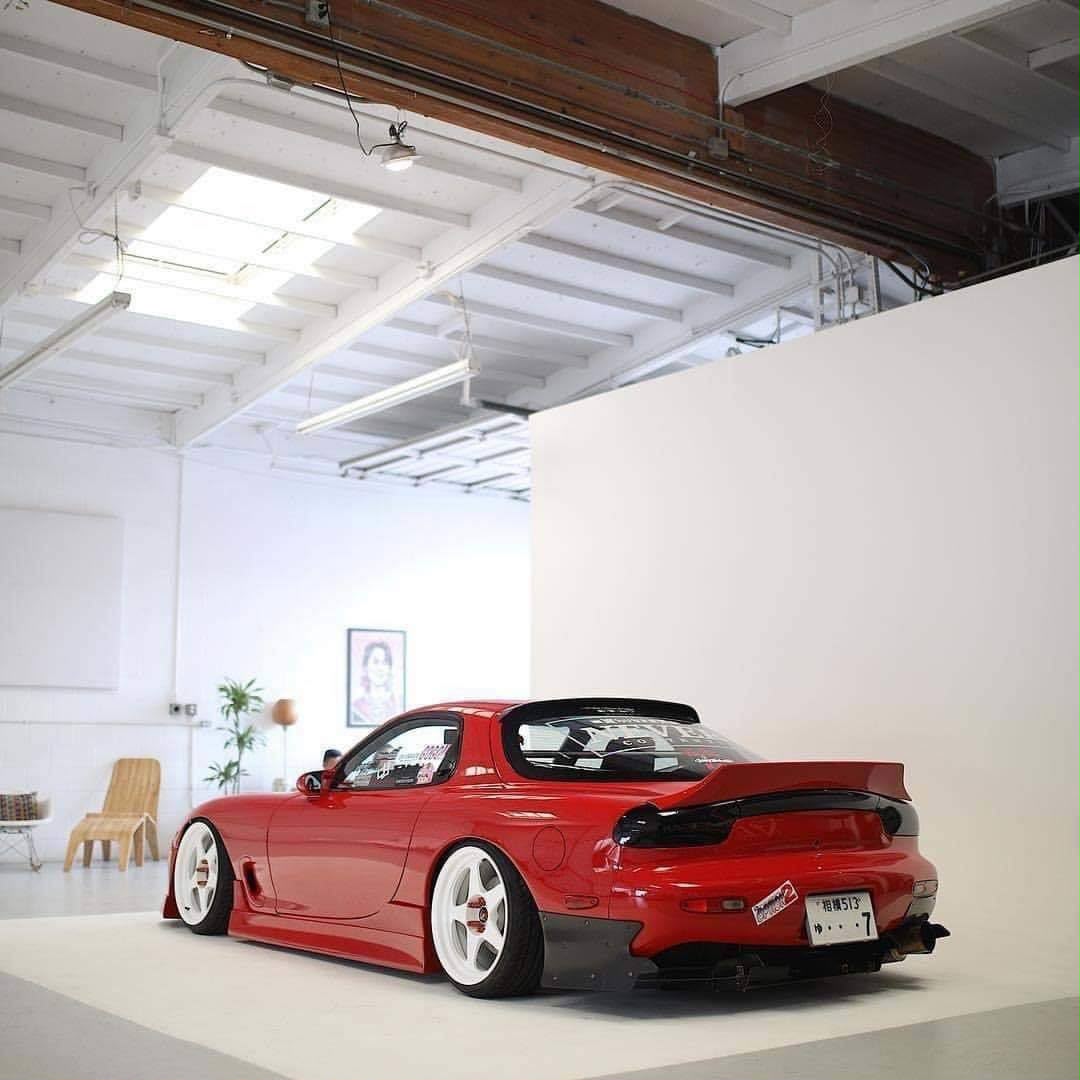 Red Mazda RX-7 displayed in a bright studio