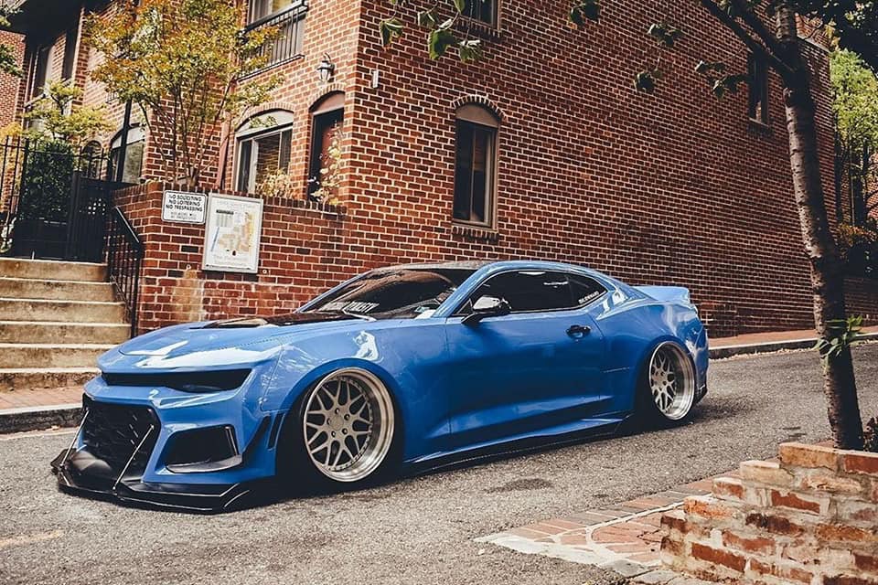 Lowered blue widebody Camaro on a city street