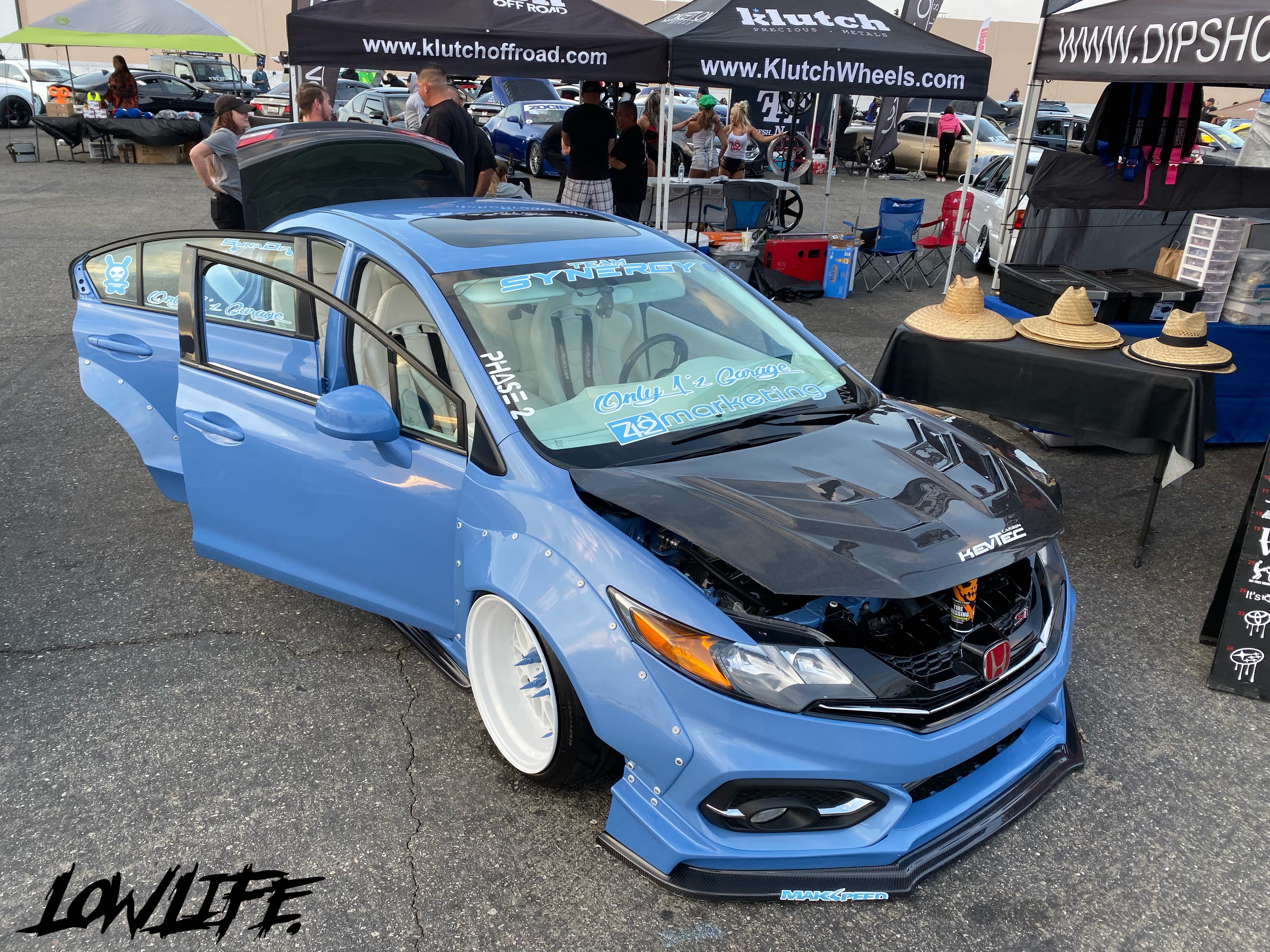 Blue widebody Honda Civic among vendor booths