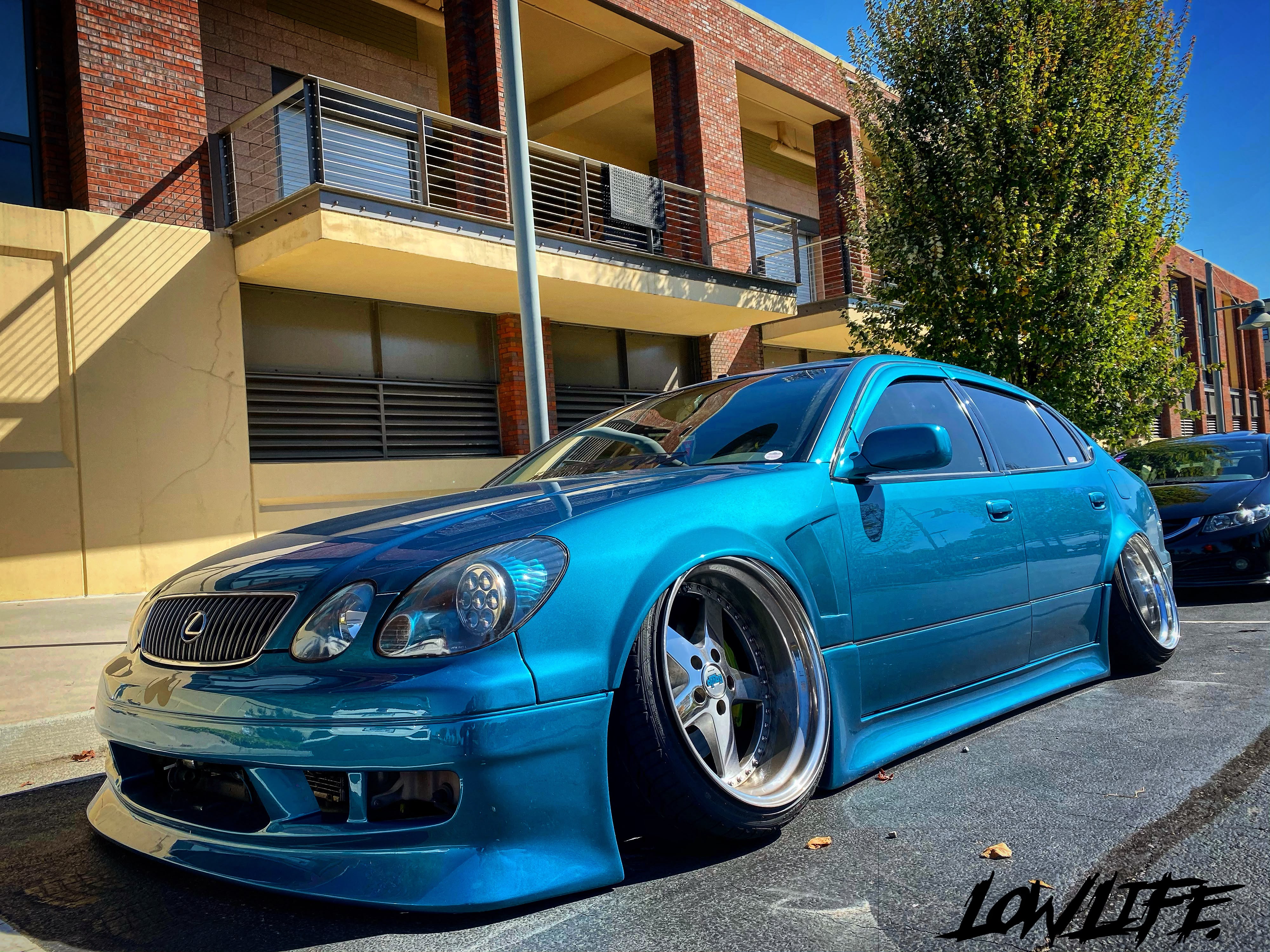 Turquoise lowered Lexus GS downtown